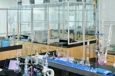 Geniş kimyasal veya bilimsel laboratuarlarda cam, mikroskop, dizüstü bilgisayar ve çeşitli test tüpleriyle modern araştırmacıların çalışma yeri