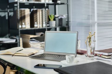 Themis 'in bronz heykeli, açık defter, içinde belgeler, çay ya da kahve bulunan dosyalar, boş ekranlı akıllı telefon.