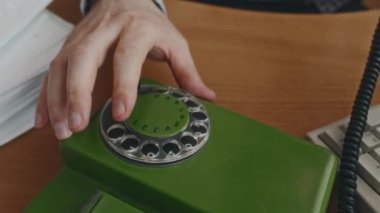 Yüksek açılı, isimsiz katiplerin el ile arama numaraları, kağıt işleri ve klavyenin yanında, 90 'lı yıllarda, ofis odasındaki ahşap masada.