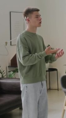 Koklear implantı olan sağır, beyaz bir çocuğun orta boy dikey çekimi, ders sırasında işaret dilinde nasıl olduğunu gösteriyor.