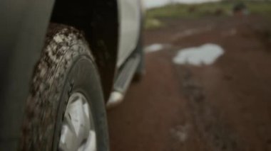 Yakın plan hiç kimse çamurlu yollarda, kırsalda çamurlu yolda, kamp yapmak için vahşi doğa güzellik merkezine giderken akşam alacakaranlıklarında çekilen piknik arabasının tekerleklerinden vurulmaz.