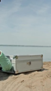 Tanımlanamayan kadın ekolojistin ellerinin dikey çekimleri test ekipmanlarıyla alan açması, cam tüp çıkarması, göldeki su kalitesi ve kirlilik seviyesini incelerken...