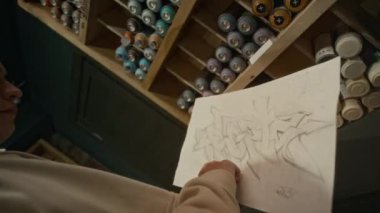 Etiket tasarımı ve sanat malzemeleri dükkanından sprey boya kutularını seçen genç bir erkek graffitistin orta boy el resmi.