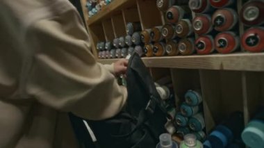 Sırt çantasına sprey boya koyarken mağazada yeni graffiti tasarımı için malzeme alan genç erkek müşterinin el kamerasıyla çekilmiş görüntüleri.