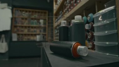 Yakın plan hiç kimse birkaç kutu sprey boyayı çekmez. Grafiti malzemeleri satan dükkanda tezgahın üzerinde, alışveriş sepetinin yanında.