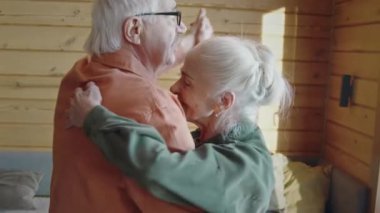 Orta boy, beyaz saçlı, uzun gümüş saçlı güzel bir kadın. Yüzünde kırışıklıklar var. Sevgili kocasıyla dans ediyor, emeklilikten zevk alıyor.