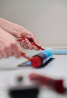 Yeni sanat eserleri yaratırken mavi baskı numunesi taşıyan tanınmayan genç zanaatkar kadınların elleri