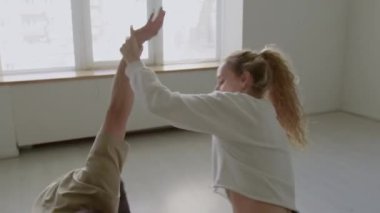 Genç yetenekli partnerler stüdyoda prova sırasında yeni koreografi öğrenirken çağdaş tarzda dans ediyorlar.