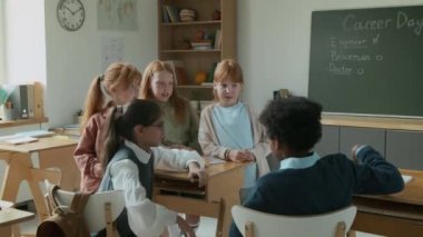10 yaşında çeşitli genç öğrencilerin tatilde eğlenmesi, siyahi oğlanın kıza sataşması, sonra İspanyol bayan öğretmenin içeri girmesi, çocukların sıralarına oturması, kariyer günü derslerine başlaması.