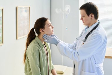 Klinik çevredeki genç bir kadın için, duvarda tıbbi ekipmanlarla kapsamlı bir sağlık muayenesi yapılıyor.