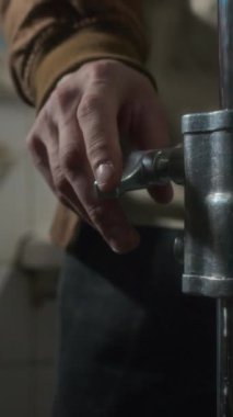 Film yapımcılığı ekipmanları için direğin yüksekliğini ayarlayan isimsiz asistanın dikey orta kesimi, kapalı alanda çekim için film setini hazırlıyor