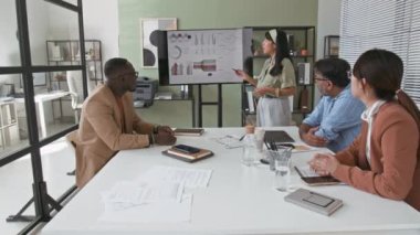 Latin asıllı genç iş kadınının dijital ekranda finansal raporunu sunarken ve iş ortaklarıyla yaptığı konferans sırasında şirket gelirinden bahsederken görüntüsünü çek.