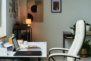 Dizüstü bilgisayarı, kırtasiyesi ve bitkileri olan modern ofis iç mimarisi minimalist tasarımı ve rahat atmosfer verimliliğini artırırken