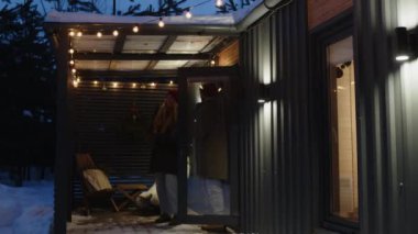 Kış kıyafetleri içinde orta yaşlı karı ve koca ışıklarla süslenmiş terasa gitmek için evden ayrılırken, Noel tatilinde kucaklaşıp birlikte vakit geçiriyorlar.