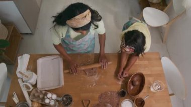 Manzarada hamur nasıl dağıtılır ve kızına oklavayı nasıl geçirilir, ev yapımı hamur işi yapmayı öğretiyor.