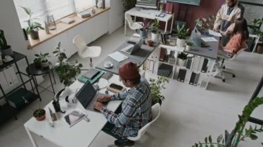 Teknoloji firmasının açık planlama ofisinde çalışan üç farklı etnik çeşitlilikte erkek ve kadın programcının geniş açılımı - bilgisayar kodu yazma, projeleri tartışma, uygulamaları geliştirme