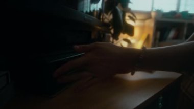 90 'lı yıllarda evinde TV' de video kaset kaydedicisine video kaset takan ve korku filmi izleyen isimsiz bir kişinin yan görüntüsü.