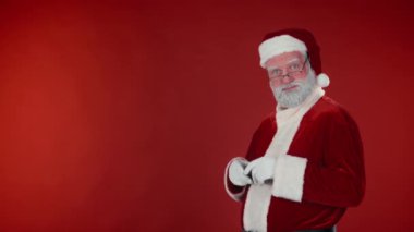 Noel Baba 'nın kostümlü orta ölçekli portresi linkini ya da ürününü gösteriyor ve müşterilere öneriyor. Kırmızı arka plana karşı iyi niyet göstergesi. Şablon için uygun, alanı kopyala