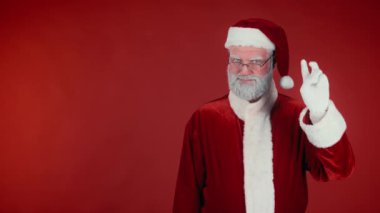 Neşeli Noel Baba 'nın orta ölçekli portresi beş saniye sayıyor ve Noel' in başlangıcını kutluyor, parti toplarını patlatıyor, kırmızı arka plandan konfetiler düşüyor, şablon ya da uzay kopyası gibi.