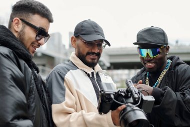 Dışarıdaki kamera görüntülerini analiz eden üç kişilik bir grup, izleme cihazına odaklandı ve kentsel alandaki takım arkadaşlarıyla sonuçları tartıştılar.