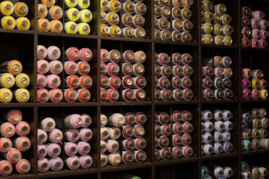 Büyük ekran, birkaç sıra kare rafla birlikte küçük dükkandaki graffiti resimleri için boya içeren sprey kutular.