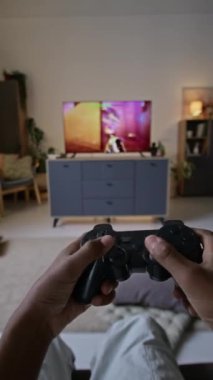 Sadece evde oyun sahası olan büyük modern TV 'de nişancı oyunu oynarken dikey POV görüntüsü