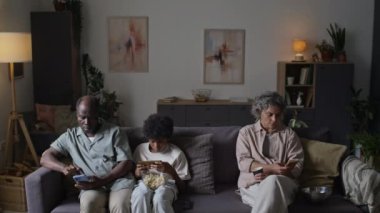 Tam orta boy dijital bağımlı aile üyeleri kanepede oturuyor ve haftasonunu akıllı telefonlarda geçiriyor, modern sosyal problem, kopyalama alanı
