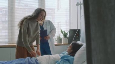 Tam orta boy erkek bebek doktoru, beyaz annesinin iyileşen kızla hastane koğuşunda konuşmasına izin veriyor.