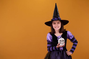 Elinde insan kafatasının maketi olan sevimli bir kız. Reklamınızın kopyası ile tecrit edilmiş bir şekilde kameraya bakıyor.