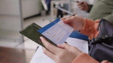 Konsolosluk sırasını beklerken belgeleri hazırlayan ve mülakat sorularını gözden geçiren tanınmayan vize başvurusunun yakın çekimleri