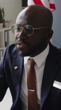 ABD büyükelçiliğindeki Müslüman bir kadınla yapılan görüşme sırasında Afrikalı Amerikalı erkek konsolosluk görevlisinin vize başvurusunu reddettiği dikey eğim.