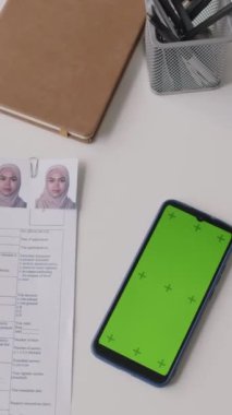 Onaylanmış vize başvuru formu, pasaport ve konsolosluktaki yeşil renkli ekranlı akıllı telefonun dikey görüntüsü yok.