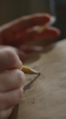 Anonim ressamın elleri ve parmaklarının dikey dikey yakın çekimi not defterine insan kafasının çizimini çiziyor, elinde yanan sigarayla stüdyoda duman bulutlarında tek başına çalışıyor.