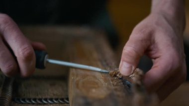 Anonim marangozun elleri, atölyede ahşap sandalyeyi döşeyip mobilyaları restore ederken tornavida kullanarak eski pedalları kaldırıyor.