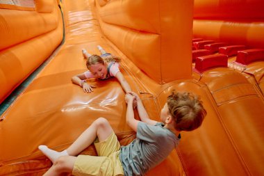 Portakal rengi deri bir kayağın üstünde uzanmış arkadaşınla eğlenirken küçük, şirin bir kız eli.