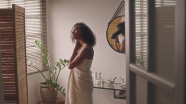 Havluya sarılı, kıvırcık saçlarını saç kurutma makinesiyle silen, duştan sonra kıvırcık kız metodunu takip eden, okula ya da işe hazırlanan, güzellik rutini