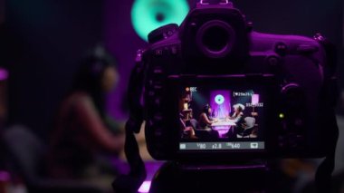 Stüdyoda mor neon ışıkla konuşan, yaşam tarzı sorunlarını tartışan ya da yeni müzik dinleyen iki genç kadının üç ayaklı kameradaki dijital kamera görüntülerini kapatın.