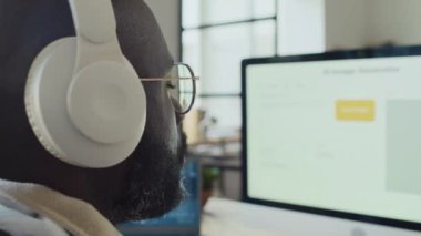 Afrika kökenli Amerikalı programcının ofis içinde yapay zeka geliştirme yazılımı üzerinde çalışması, bilgisayar üzerinde ürünü test etmesi, müzik dinlerken kulaklığı ayarlaması