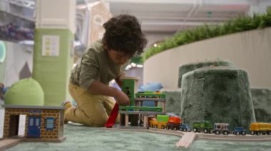 Kapalı alandaki çocuk parkında oyuncaklarla oynayan küçük siyahi çocuğun düşük açılı görüntüsü