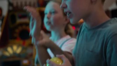 Beyazlı erkek ve kızın oyun makinelerinde boş zamanlarında oyun oynarken elde çekilmiş bir fotoğrafı.