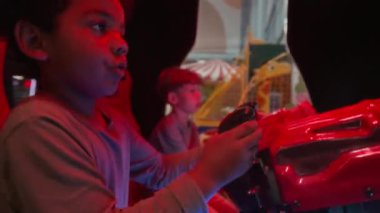 Oyun merkezinde çocuklar için kumar makineleri kullanan çeşitli çocukların el kameraları.