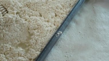 Manzara hiç kimse beyaz-sarı kütleli taze pişmiş lor kütlelerinin borudan aktığını ve zanaatkar peynir fabrikasında metal lavaboda aktığını göremez.