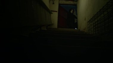 İsimsiz maskeli bir suçlunun kafasında çuval ve elleri bağlı halde rehine taşırken karanlık bodruma inerken, insan kaçakçılığı ve adam kaçırırken tam teçhizatlı bir fotoğrafı.