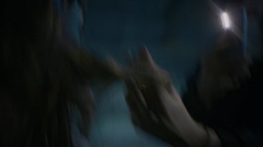 Tutsak bir kadının saçına dokunan ve onu karanlık bir bodrumda tutarken akıllı telefondan fotoğraf çeken sapkın maskeli manyağın el kamerası görüntüsü.