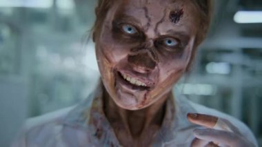 Kafkas kadın zombi hemşirenin ya da doktorun kanlı beyaz önlük giymiş, kameraya homurdanan tüyler ürpertici beyaz gözlü, işi bitkinlik ve yorgunluktan muzdarip yüzünün yakın plan portresi.