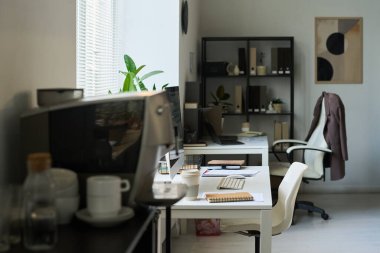 Masalarında masaüstü bilgisayarları, not defterleri ve diğer ofis malzemeleri olan modern ekonomistlerin veya yöneticilerin işyerleri