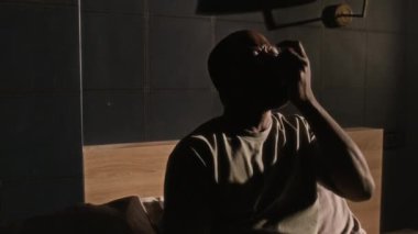 Olgun siyahi adam astım krizi geçiriyor, öksürüyor ve evde tıbbi sprey kullanıyor.