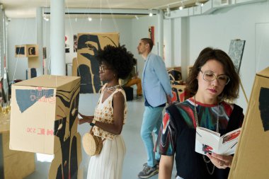 Modern sanat galerisinin genç kültürler arası ziyaretçileri çeşitli sergilerle yeni sergilere katılıyorlar.