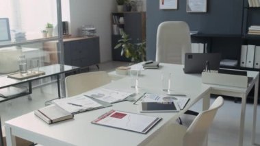 Toplantı masasında not defterleri, belgeler, dijital tablet ve dizüstü bilgisayar ile tıbbi ofis içi