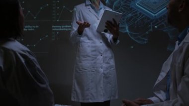 Kadın nörobiyolog elinde tablet tutarken ve sağlık hizmetleri yenilik konferansı sırasında seyircilerin önünde sunum yaparken görüntüyü büyüt